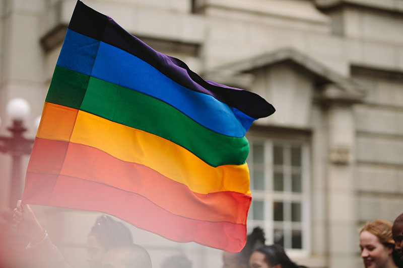 a Pride flag unfurled at a rally.