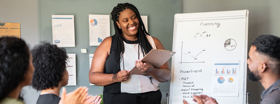 Black businesswoman giving a flipchart presentation in an office.