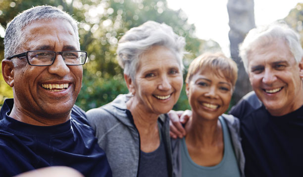 A group of smiling older people on a hike in the wood