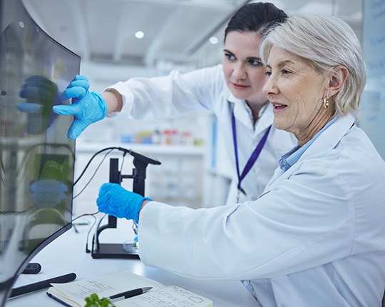 A senior scientist teaching her fellow staff member.