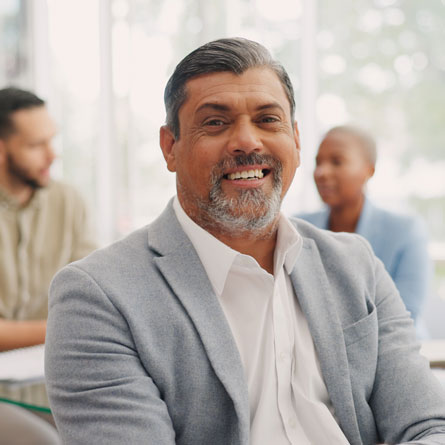 A well-dressed older man, smiling.