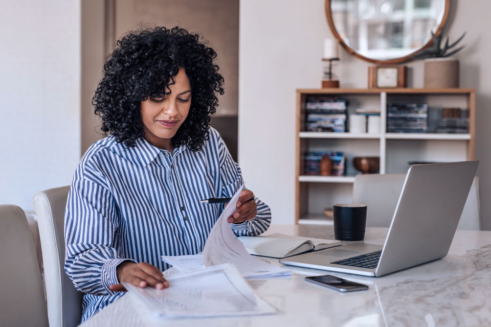 A female contractor working on her laptop at home.