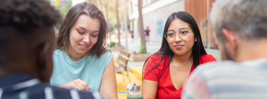 Young multiracial colleagues having drinks during lunch break.