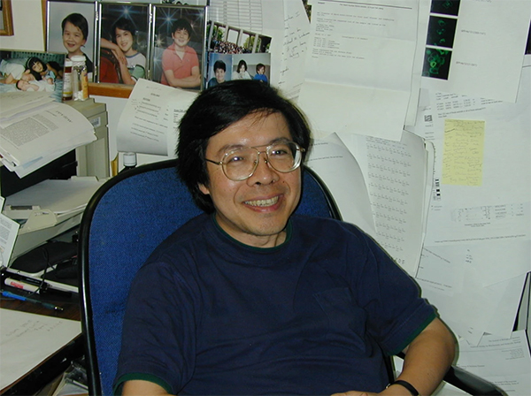 Dr. Kuan-Teh Jeang sitting at his desk.