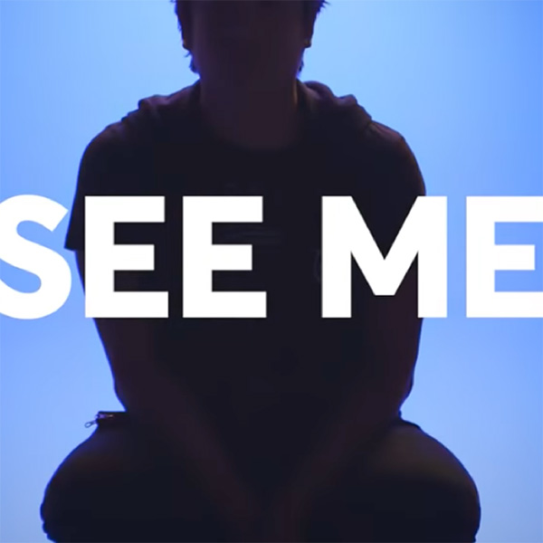 The words See Me overlayed onto the silhouette of a man sitting in a chair.