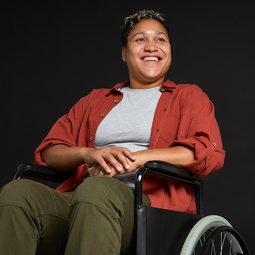 Smiling black woman sitting in a wheelchair.
