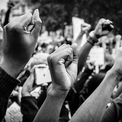 Black and white photo of fists raised in protest