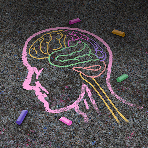 Colorful chalk drawing of a facial profile on asphalt