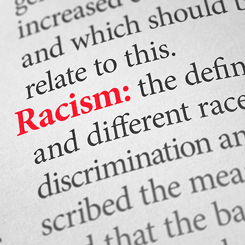 Close-up of printed text defining Racism from a page in a book