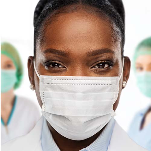 An african-american woman wearing a lab coat and a surgical mask