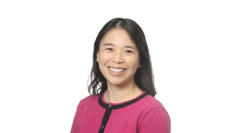 Photo of the author Serena Chu, a smiling Chinese-American woman wearing a pink cardigan. 