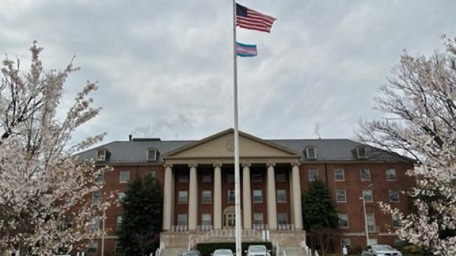 The United States and Transgender Pride flag flying in front of Building 1, the main building of NIH.